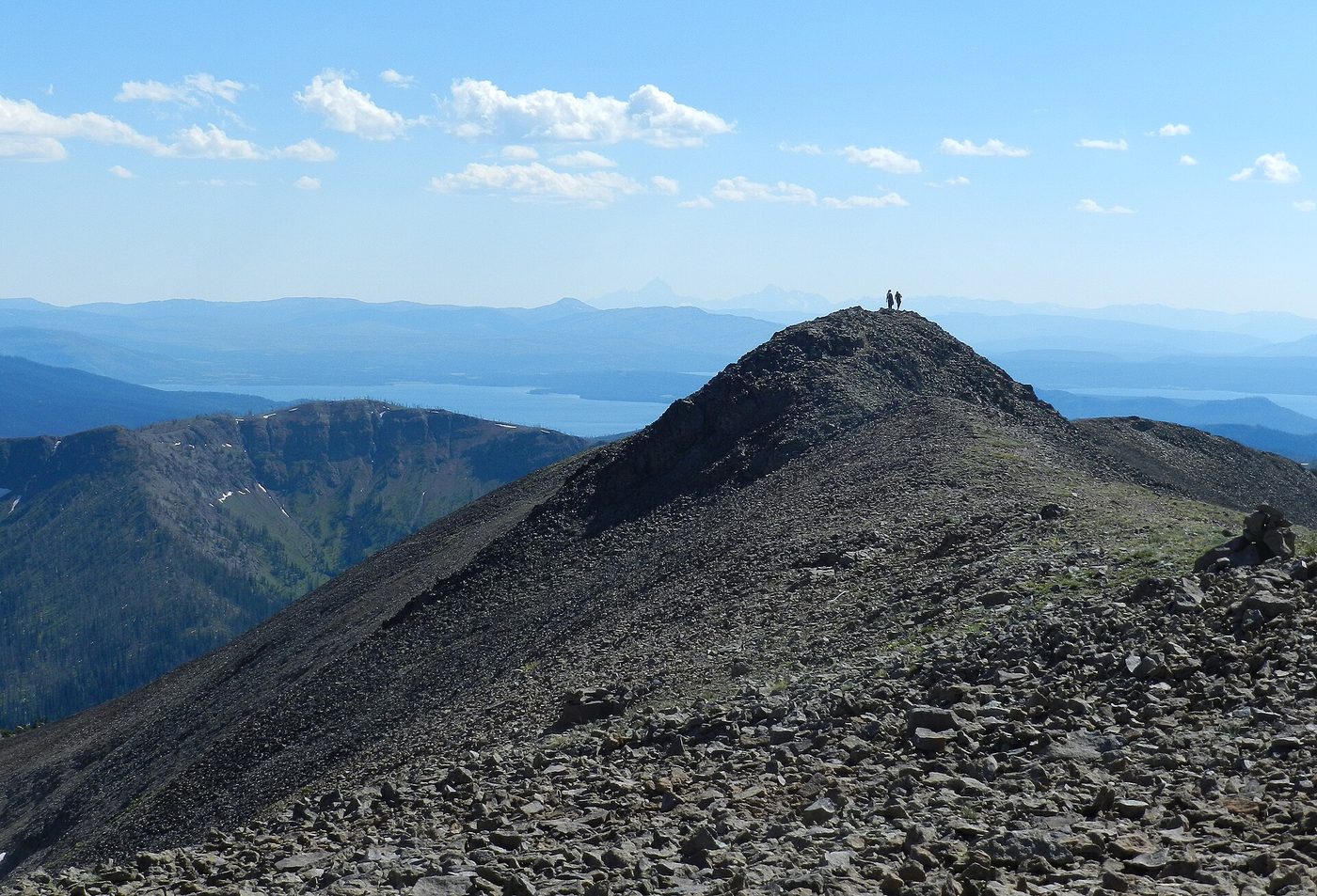 Hikers on a bare summit with Yellowstone Lake stretching to the horizon
