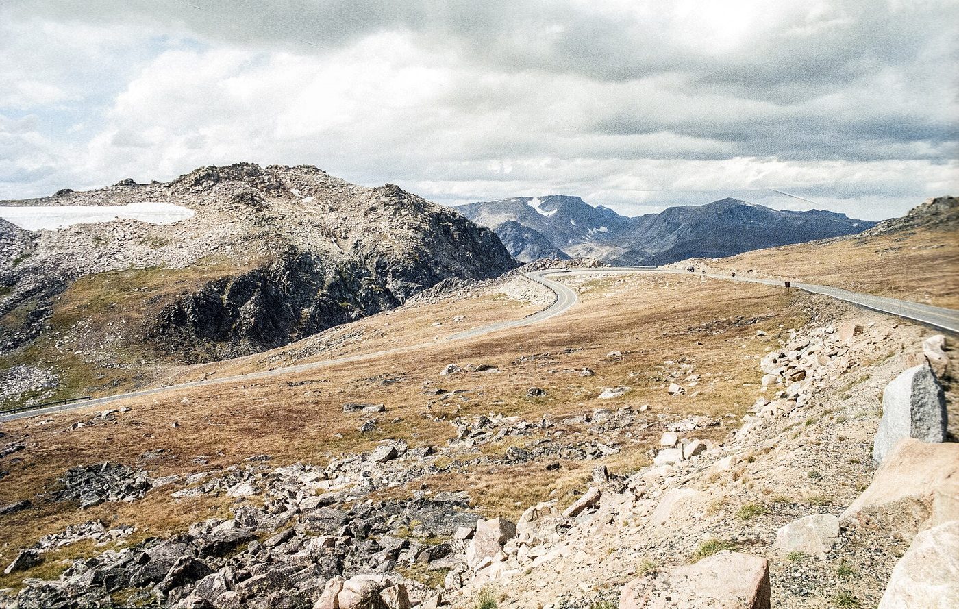 The Beartooth Highway winding across a rocky alpine plateau with snow patches