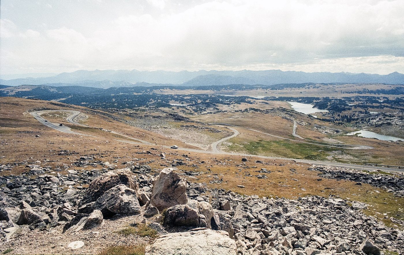 Rocky alpine tundra and the road descending from Beartooth Pass toward distant plains