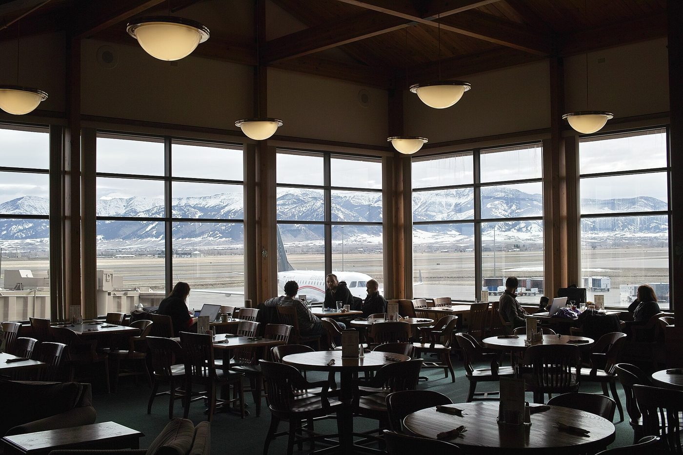 Restaurant with tall windows overlooking the runway and mountains at the Bozeman airport