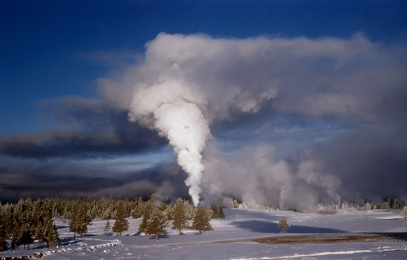 Castle Geyser's roaring steam phase billowing over a snowy geyser basin