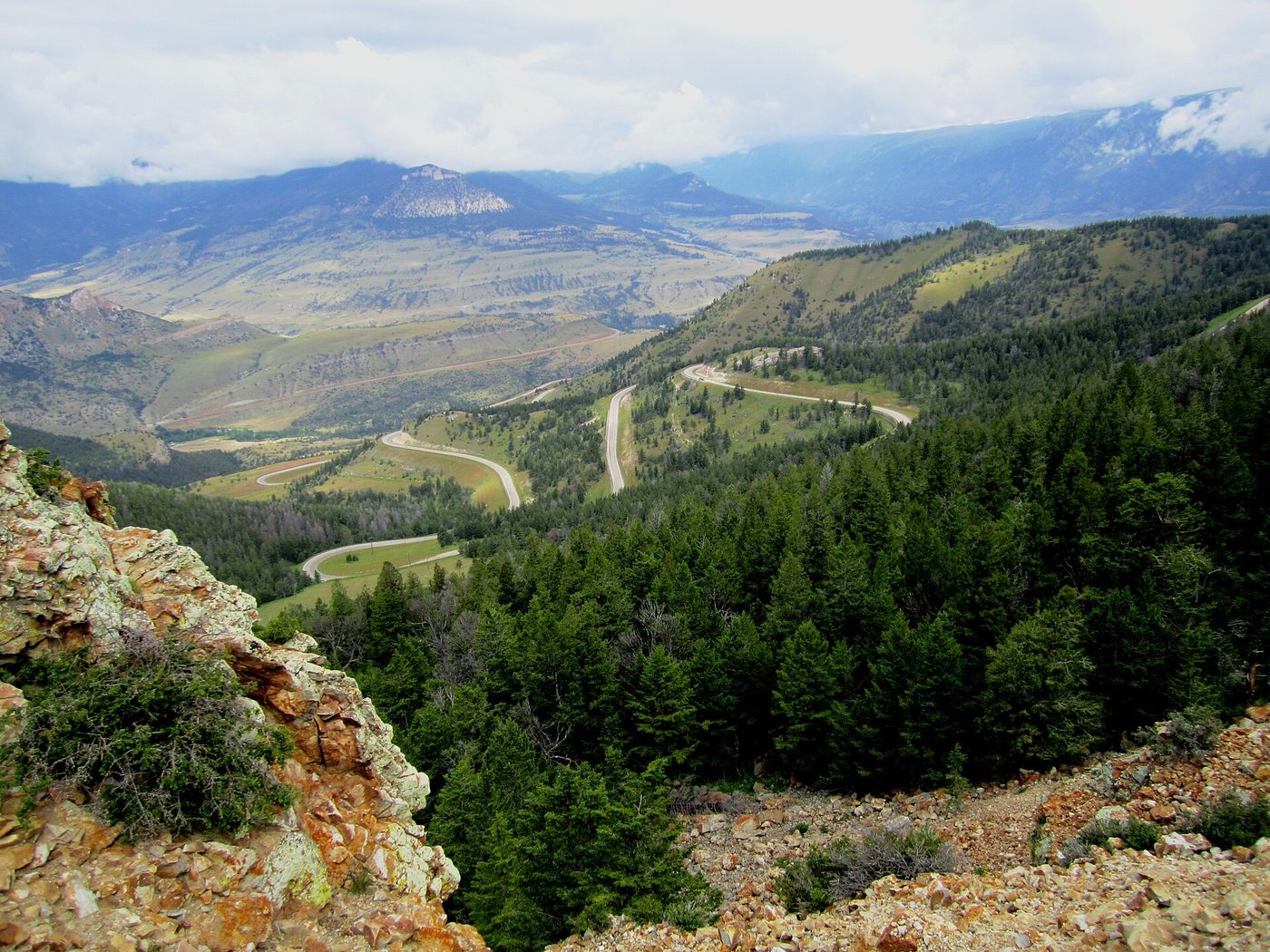 View from Dead Indian Pass over forested ridges and the road looping into the valley
