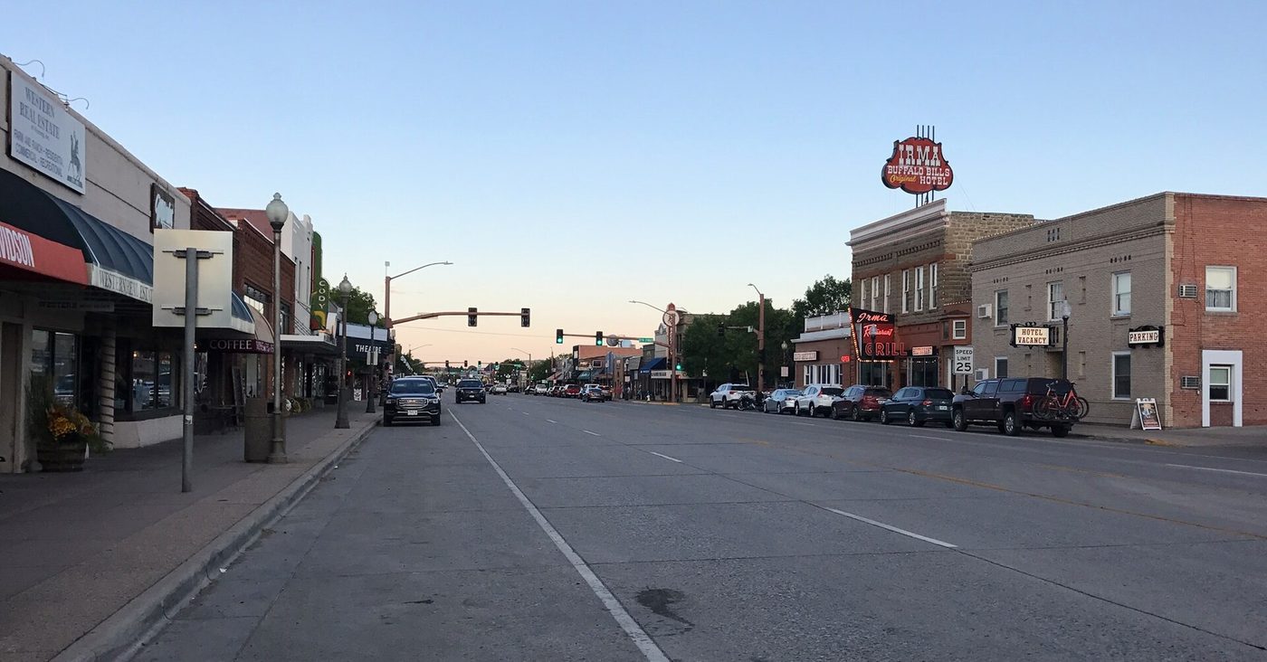 The wide main street of Sheridan Avenue in Cody, Wyoming, lined with low brick buildings