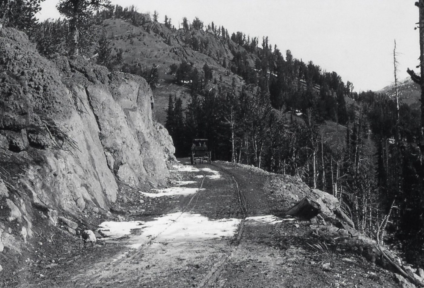 Black-and-white photograph of a narrow early road cut into a cliff on Dunraven Pass