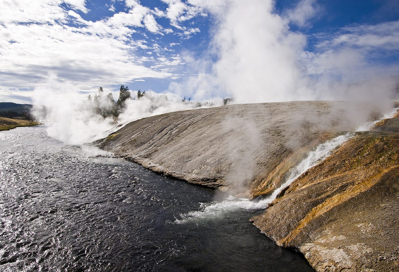 Hot water from Excelsior Geyser spilling down a sinter bank into the Firehole River