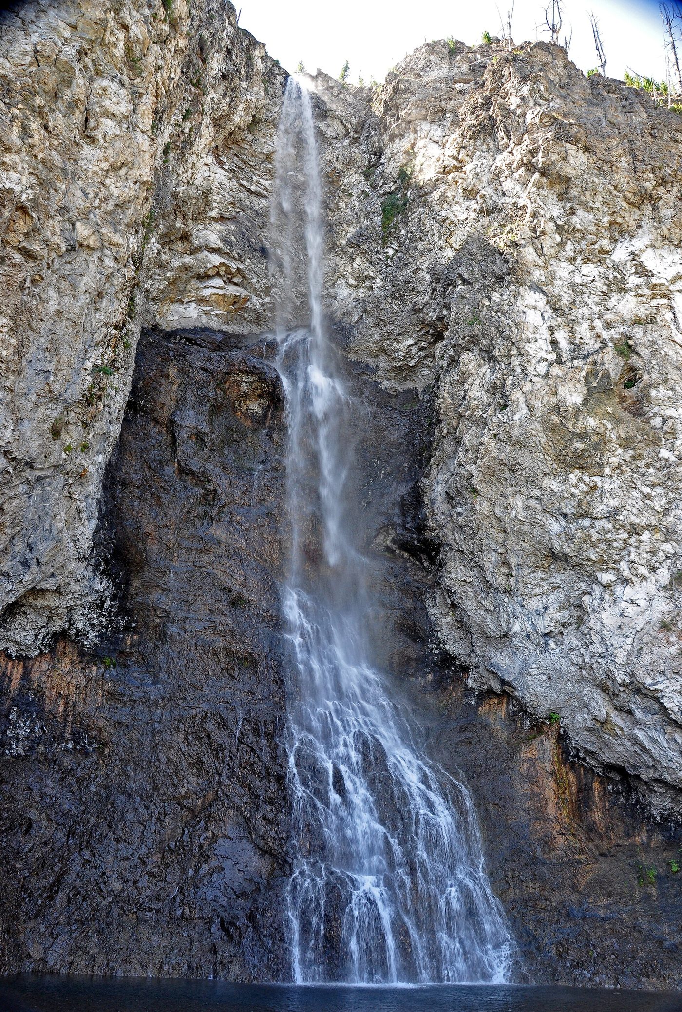 Fairy Falls dropping in a thin ribbon down a pale cliff into a pool
