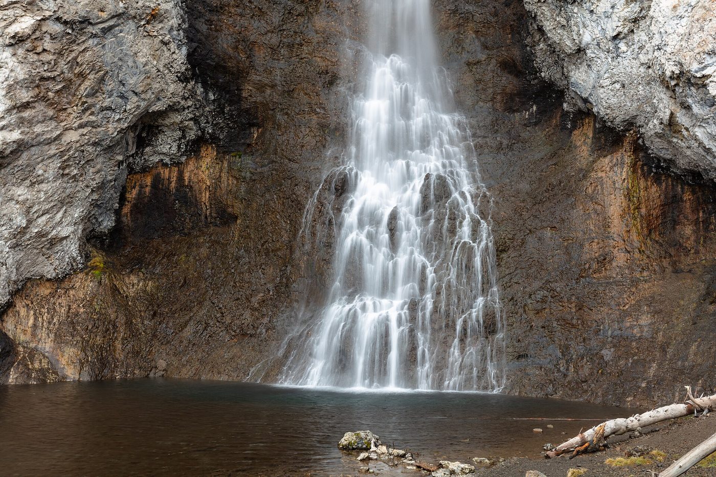 Fairy Falls plunging from a cliff into a dark pool at the base of the Madison Plateau
