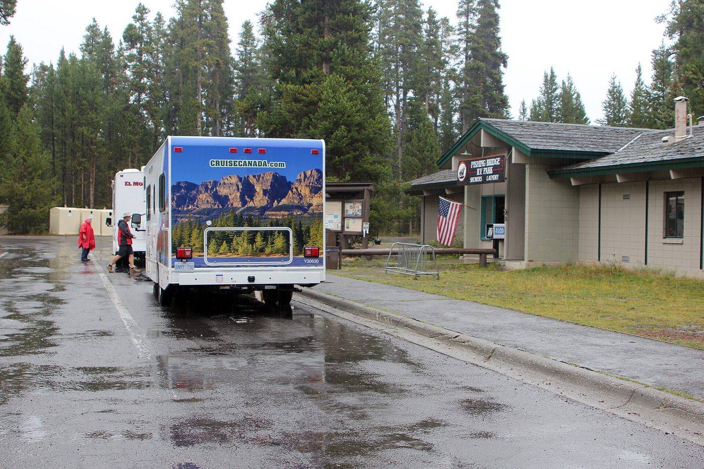 An RV and the registration buildings at Fishing Bridge RV Park on a wet morning
