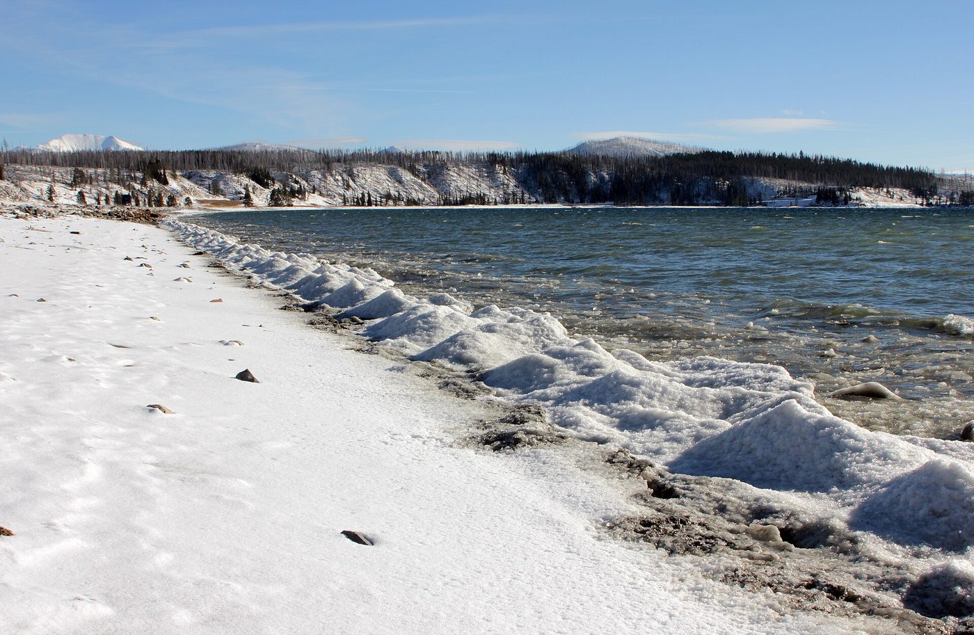 Ridges of ice and snow along the north shore of the lake with open water beyond