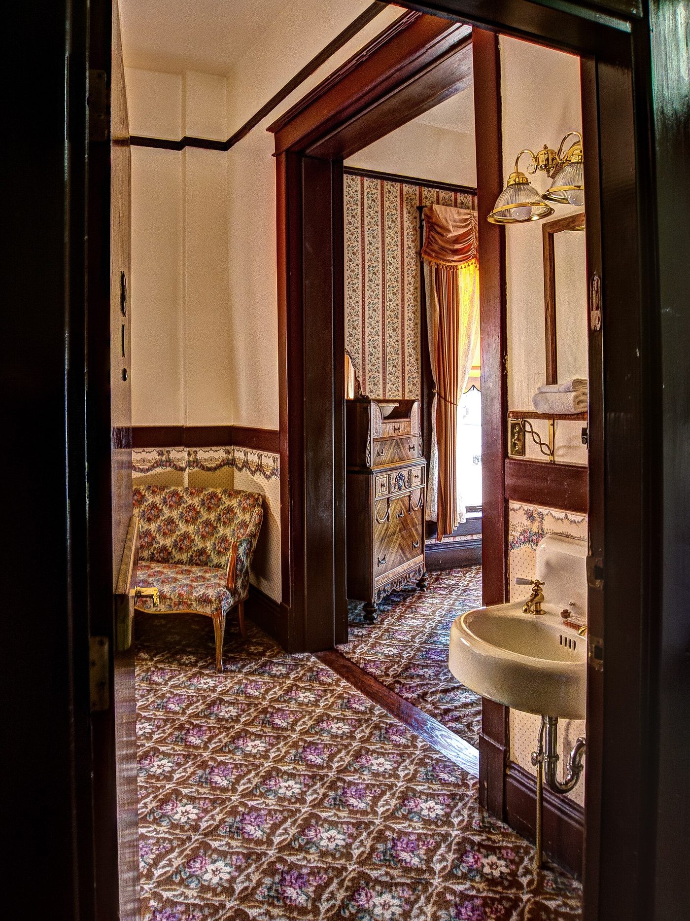 A patterned carpet and period furnishings in a suite inside the historic Irma Hotel