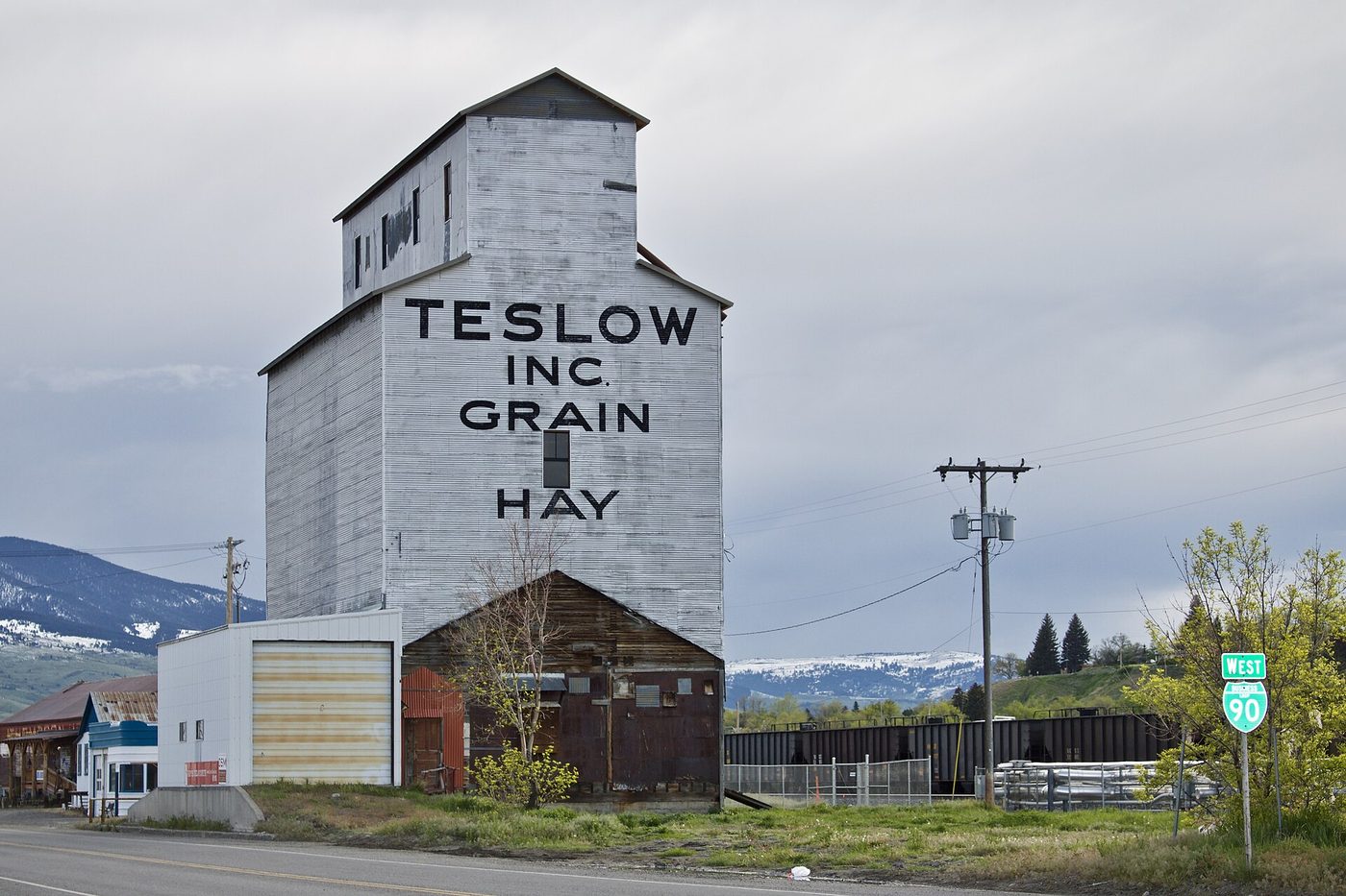 The tall painted Teslow grain elevator beside the railroad tracks in Livingston, Montana
