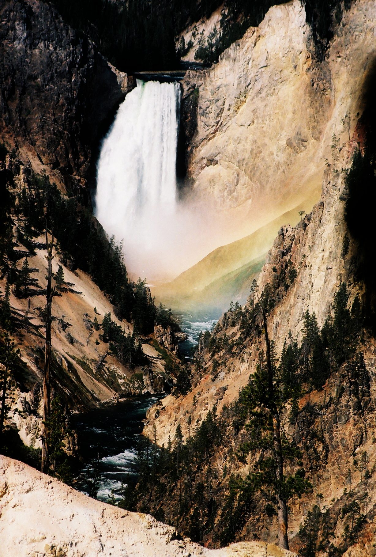 A rainbow forming in the spray at the base of the Lower Falls of the Yellowstone River