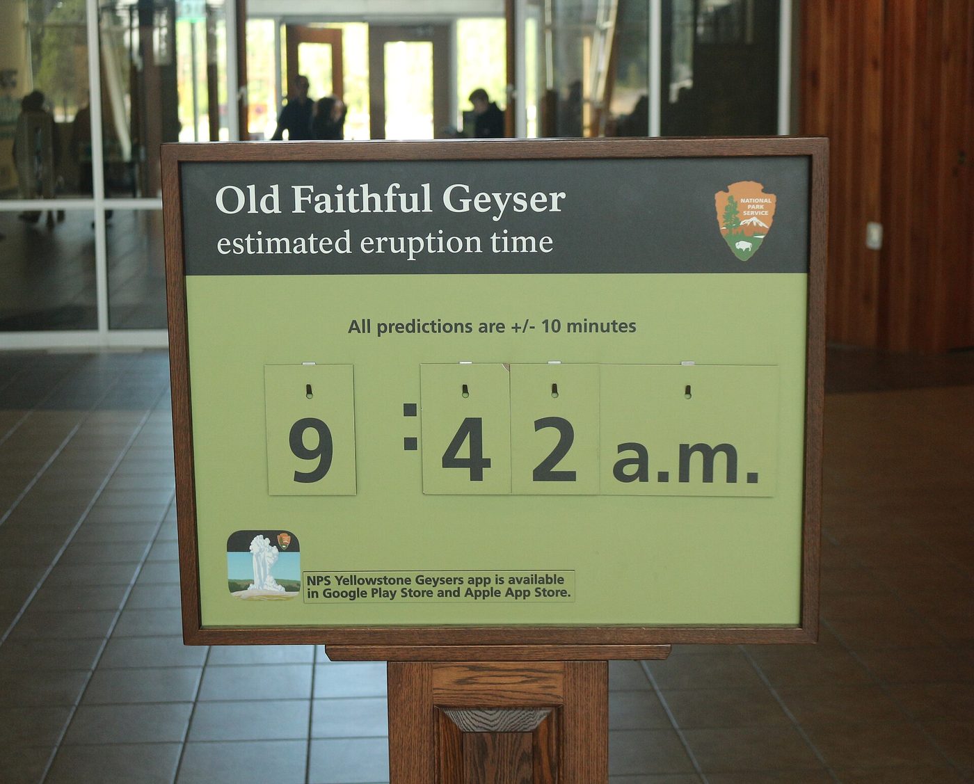 An NPS sign at the Old Faithful Visitor Education Center giving the next estimated eruption time of Old Faithful Geyser