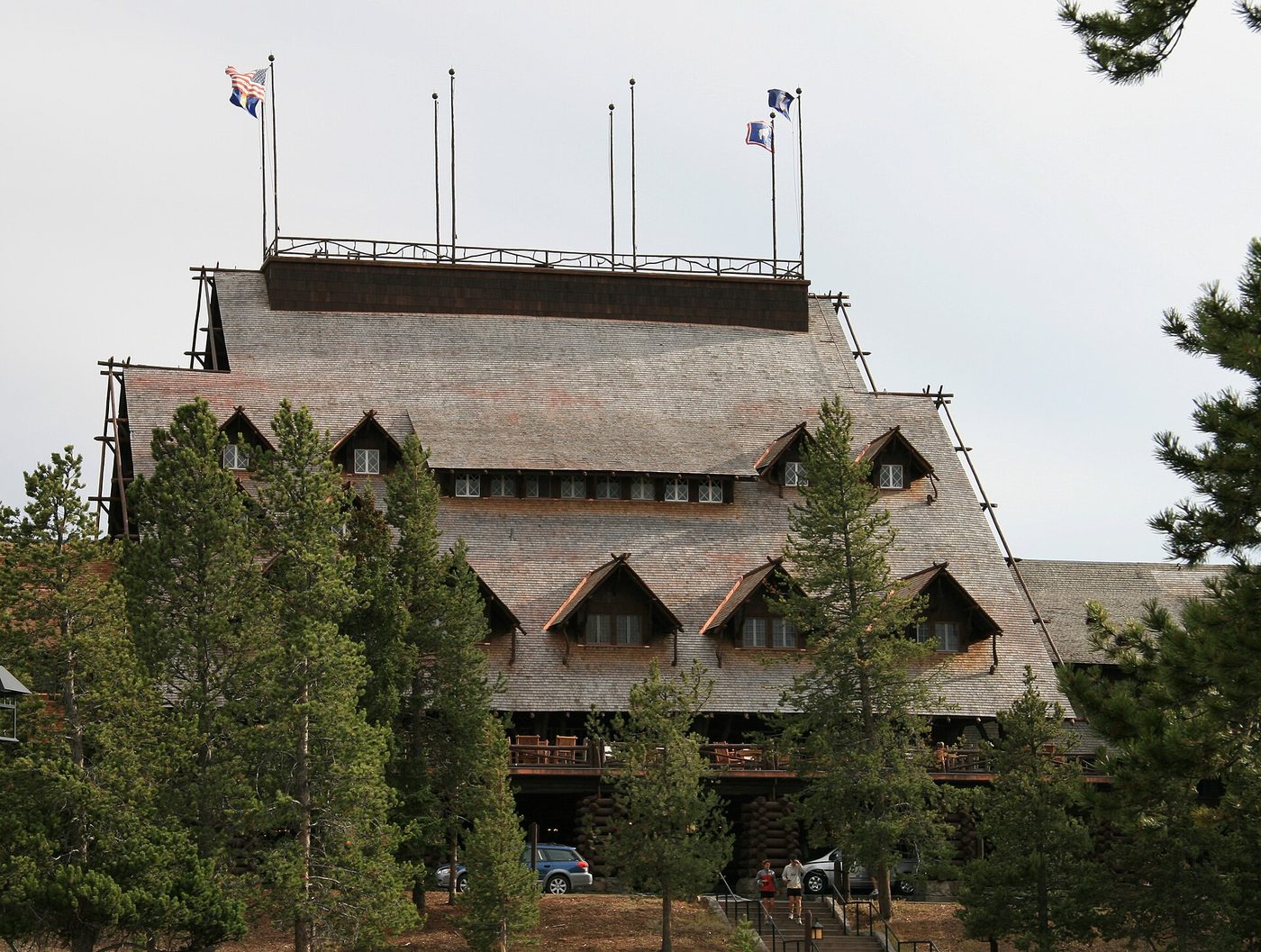 The steep shingled gables and flag-topped roof walk of the 1904 log hotel at Old Faithful
