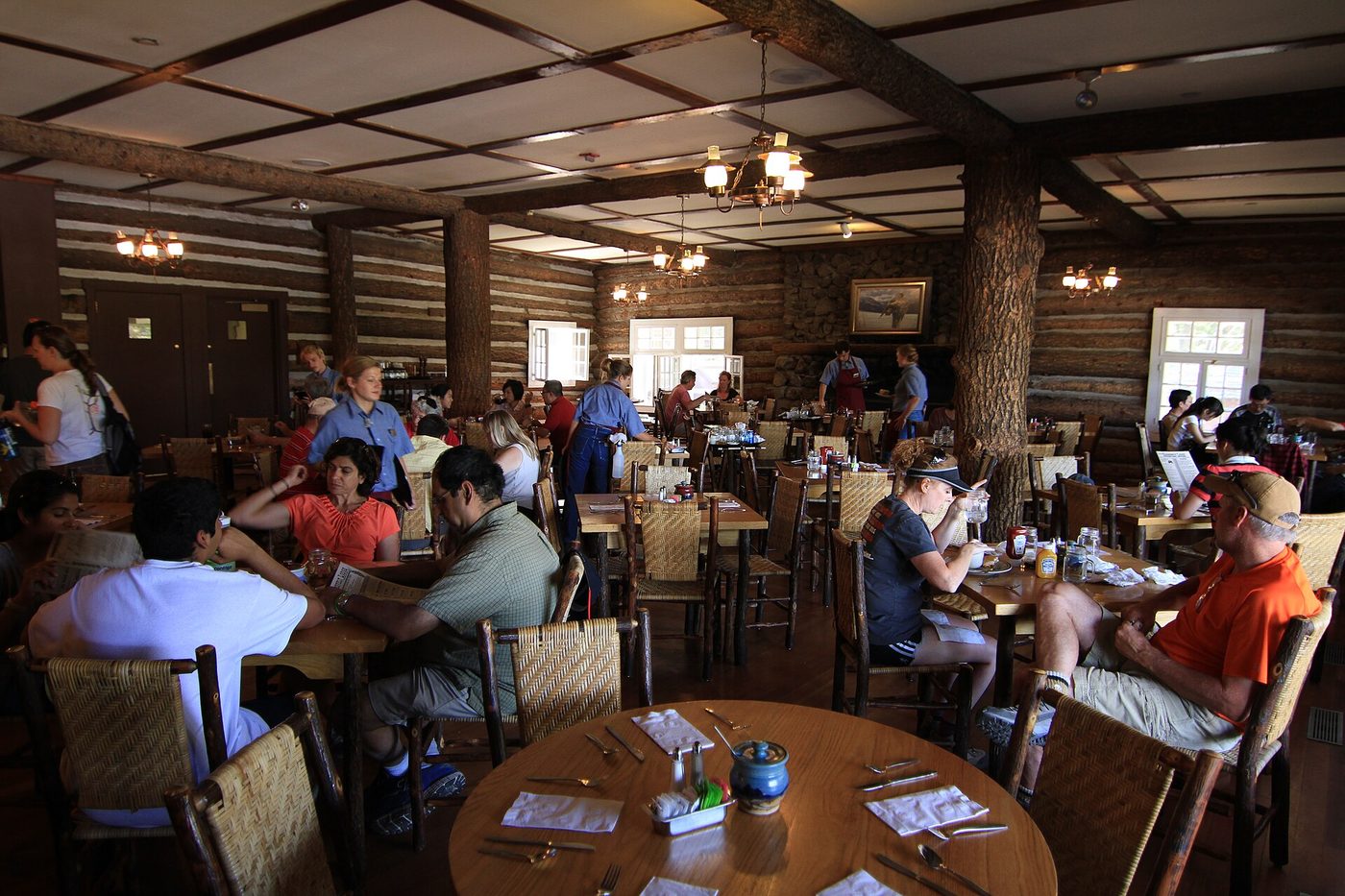Guests eating at wooden tables in the rustic Roosevelt Lodge dining room
