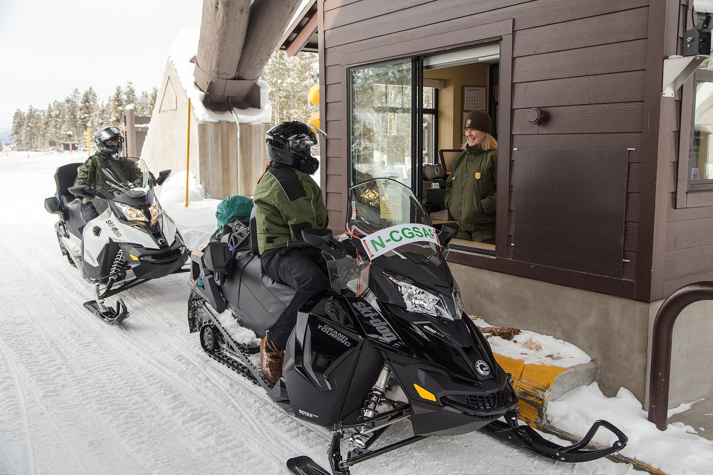 Snowmobilers stopped at the West Entrance booth in winter