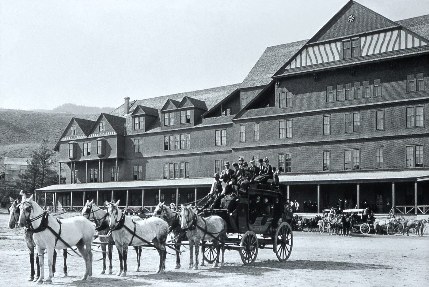 A historic photograph of a loaded stagecoach and six horses in front of the old Mammoth hotel