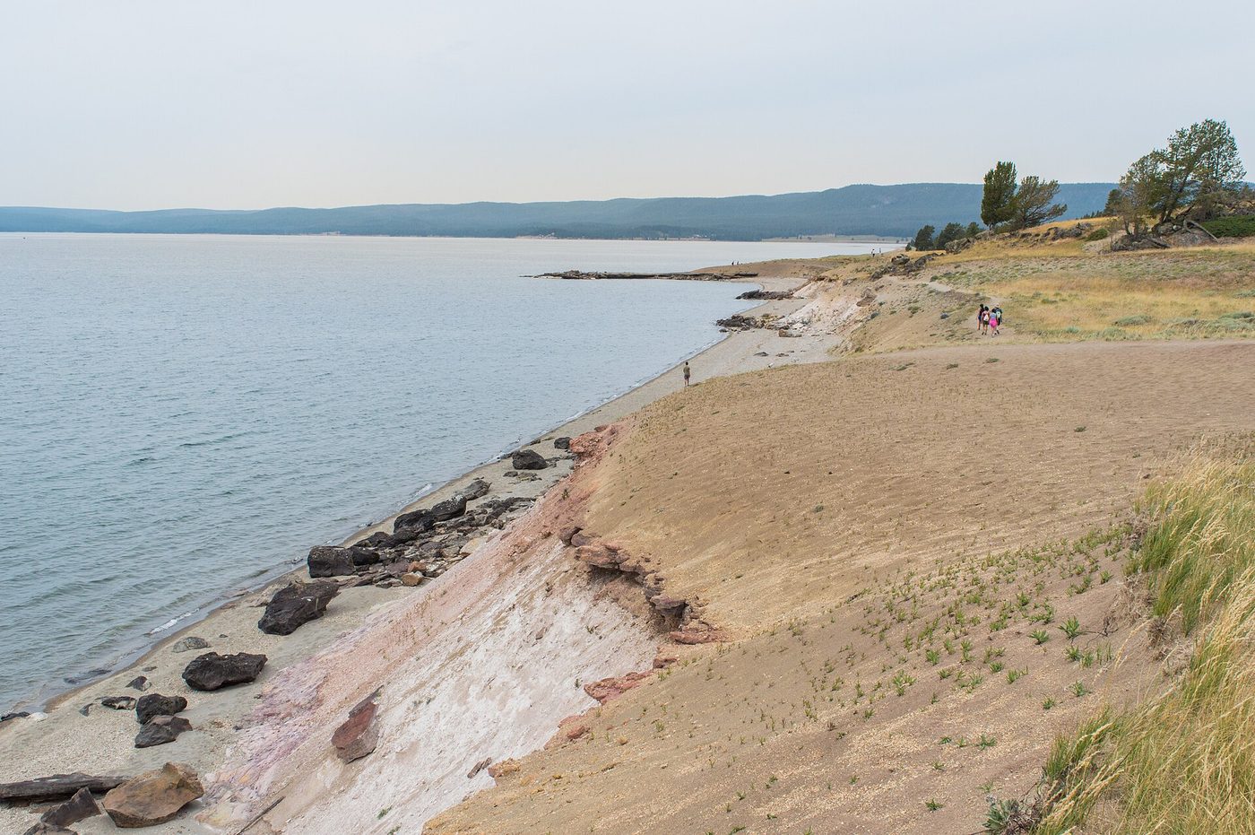 An eroded sandy bank and rocky beach along the lake on the Storm Point Trail