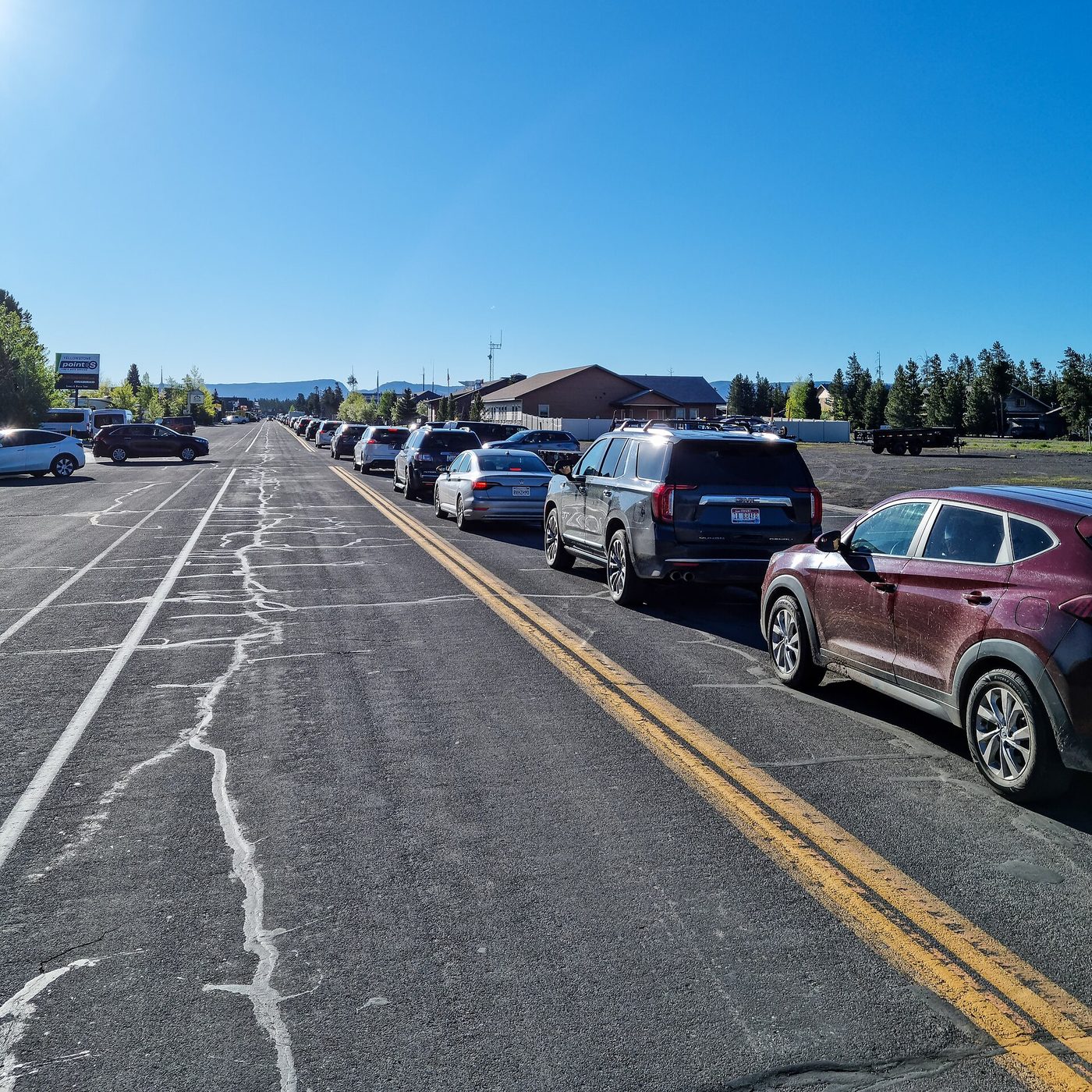 A long line of cars waiting on Yellowstone Avenue to reach the West Entrance station