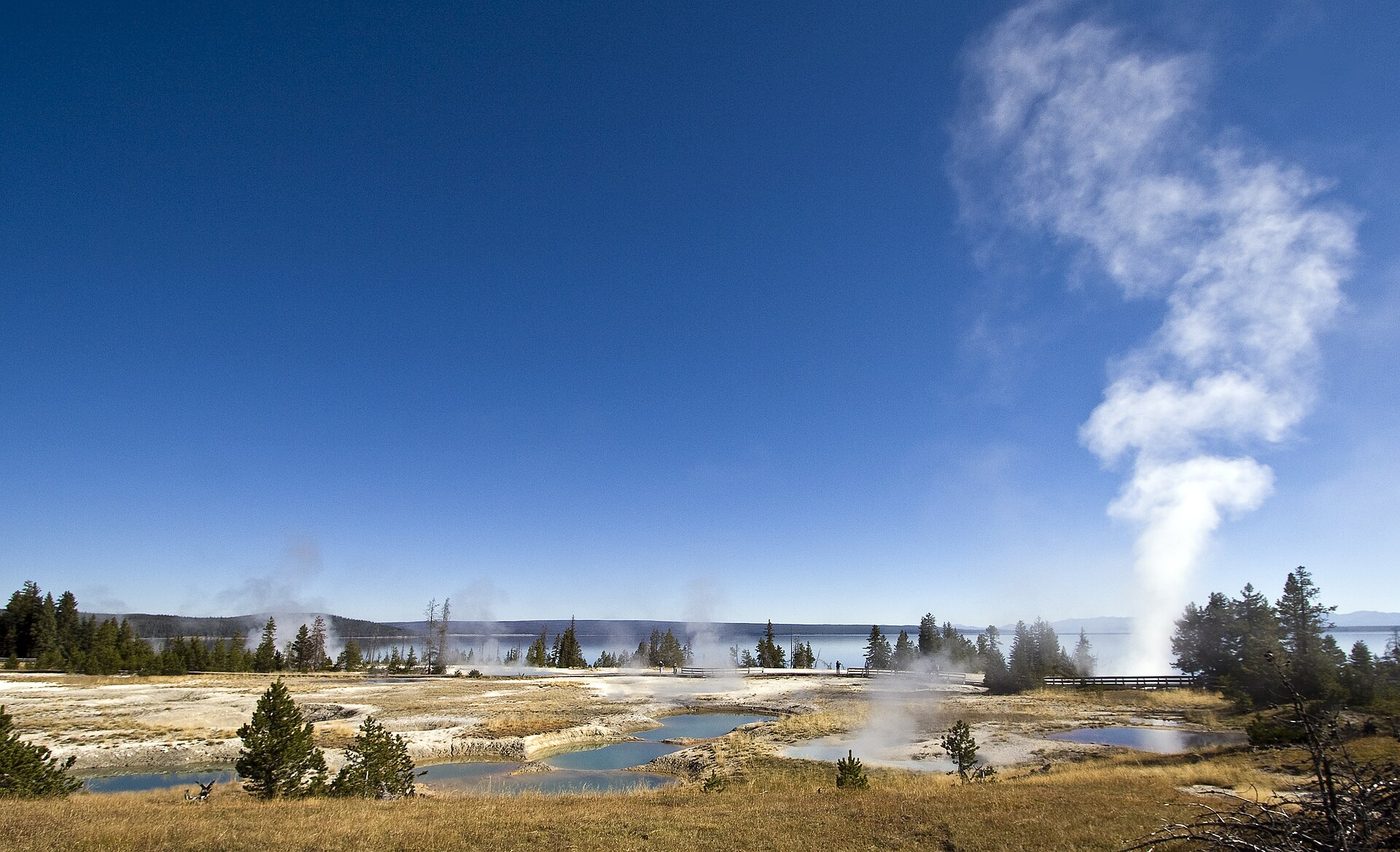Hot springs and a rising steam plume at West Thumb Geyser Basin with Yellowstone Lake behind