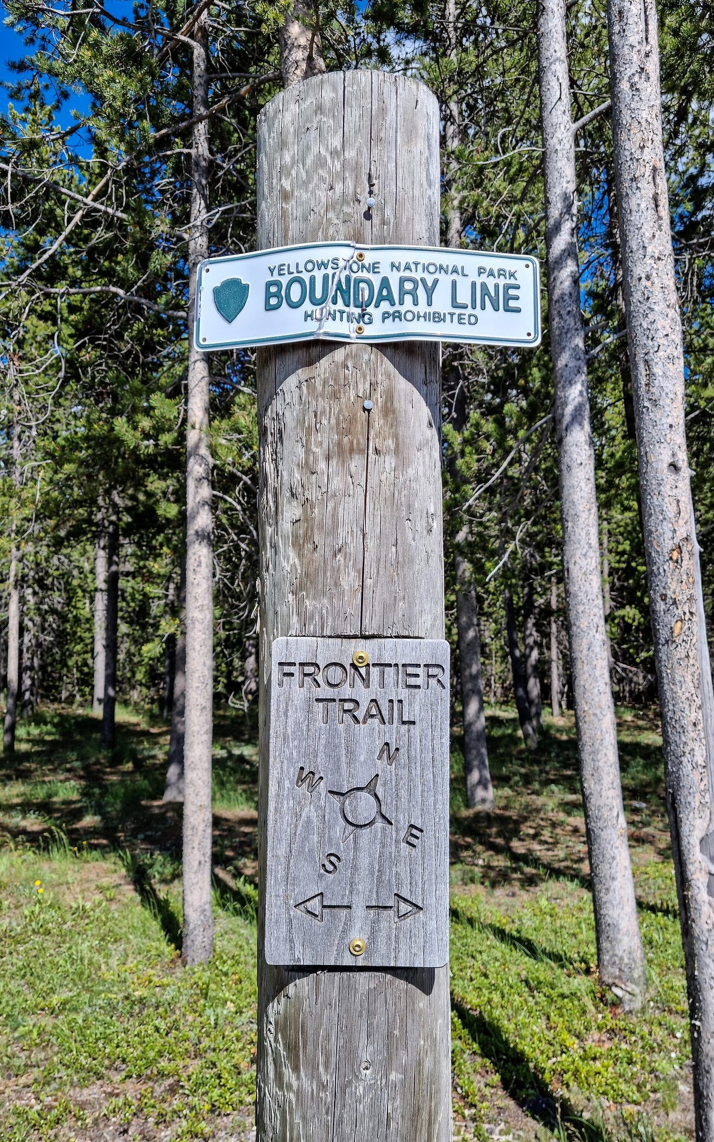 A wooden park boundary post marking the Yellowstone line at Boundary Street in West Yellowstone